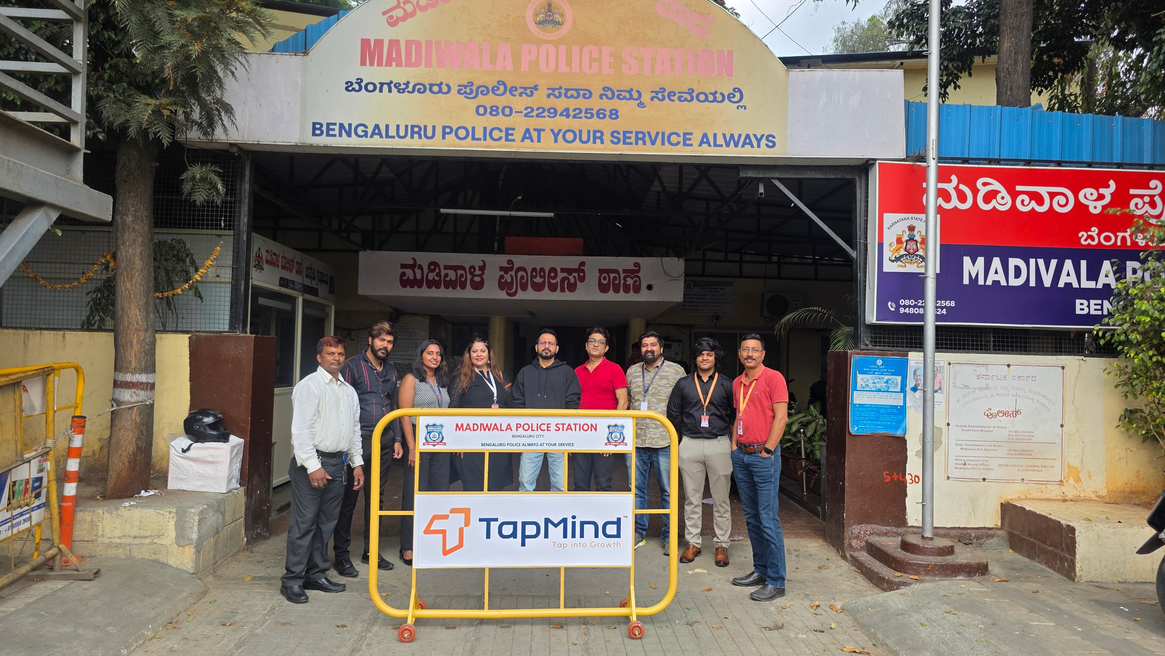 TapMind representatives and police officers with road barricades outside Madivala Police Station