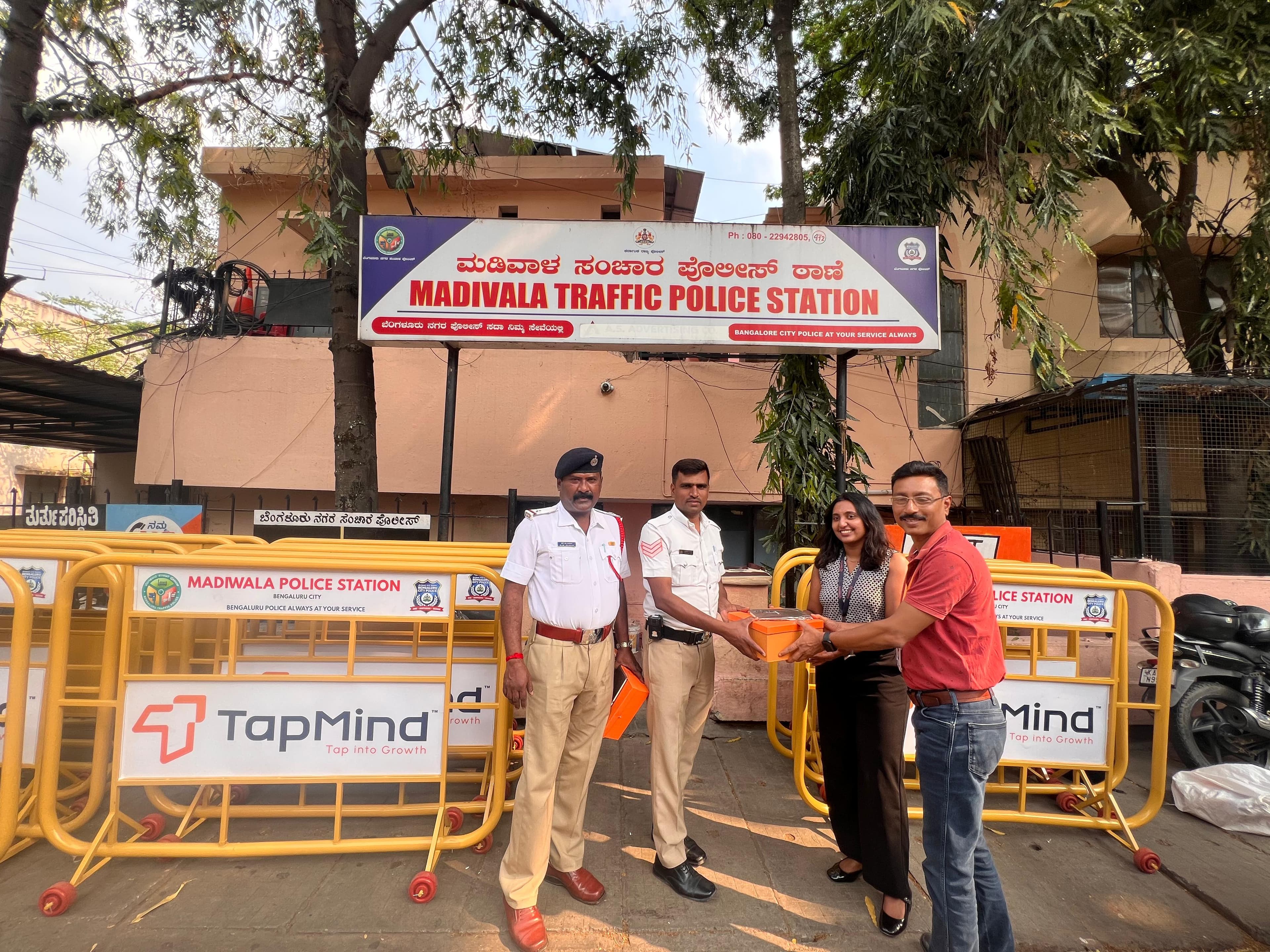 TapMind representatives and traffic police beside branded road barricades